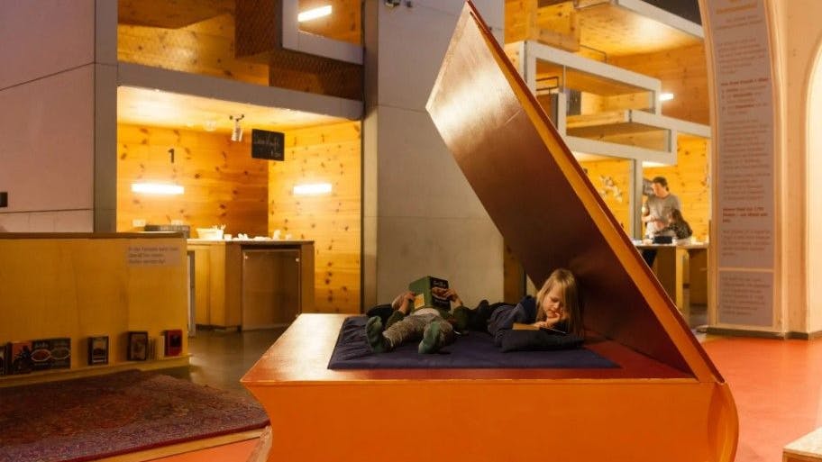 Im „Mach mit“-Museum können Kinder im Buchbett in Büchern schmökern.