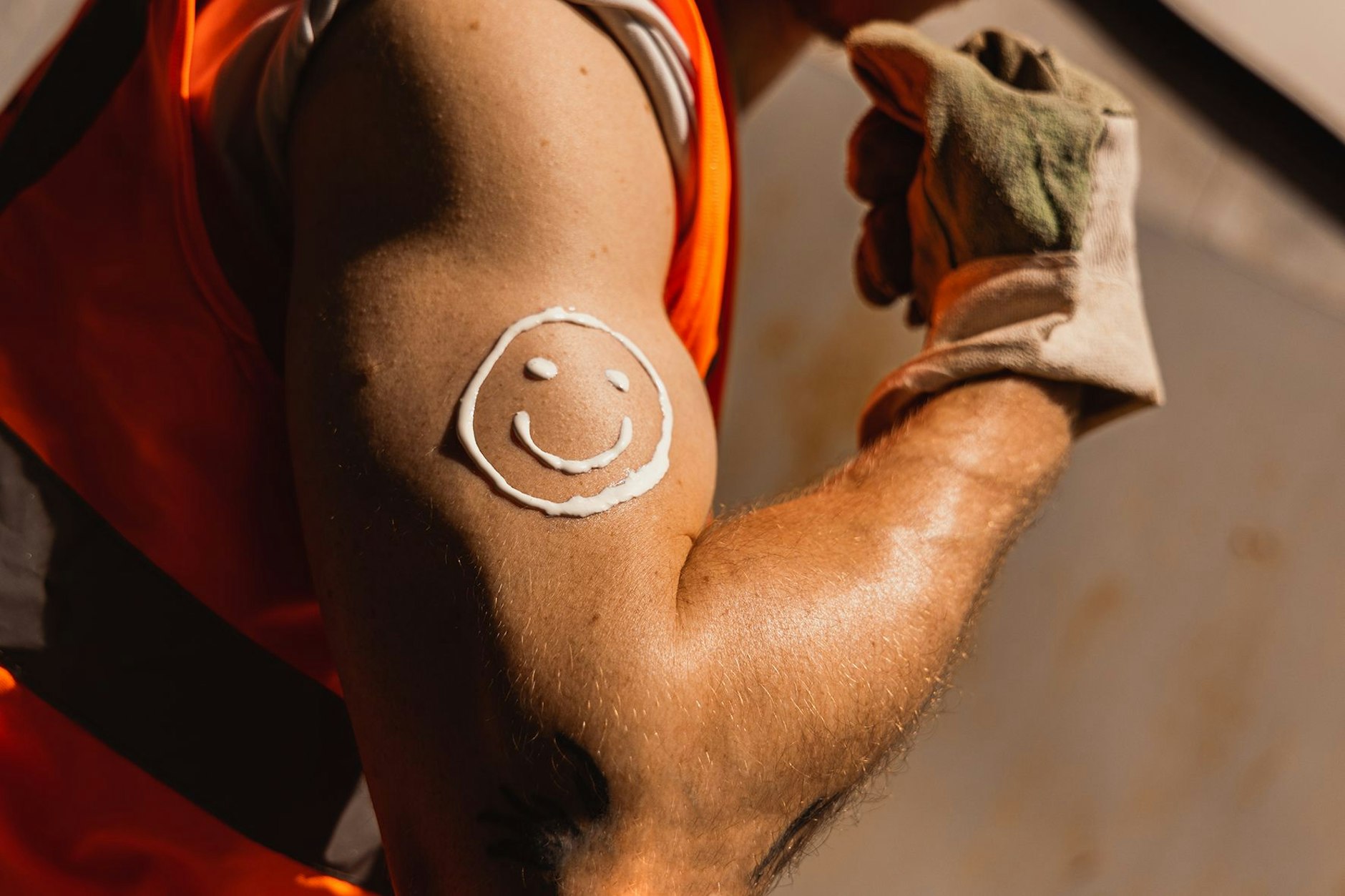 Ein Bauarbeiter mit Sonnenmilch auf dem Arm. Besonders Menschen, die draußen arbeiten, können der Hitze schlecht entfliehen. Eine Gewerkschaft fordert für sie kostenlose Sonnencreme.