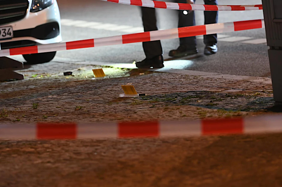 Polizisten sichern Projektile auf dem Gehweg: Am Dienstagabend wurde in der Neuendorfer Straße in Spandau ein Mann niedergeschossen und schwer verletzt. Der Hintergrund ist unklar.