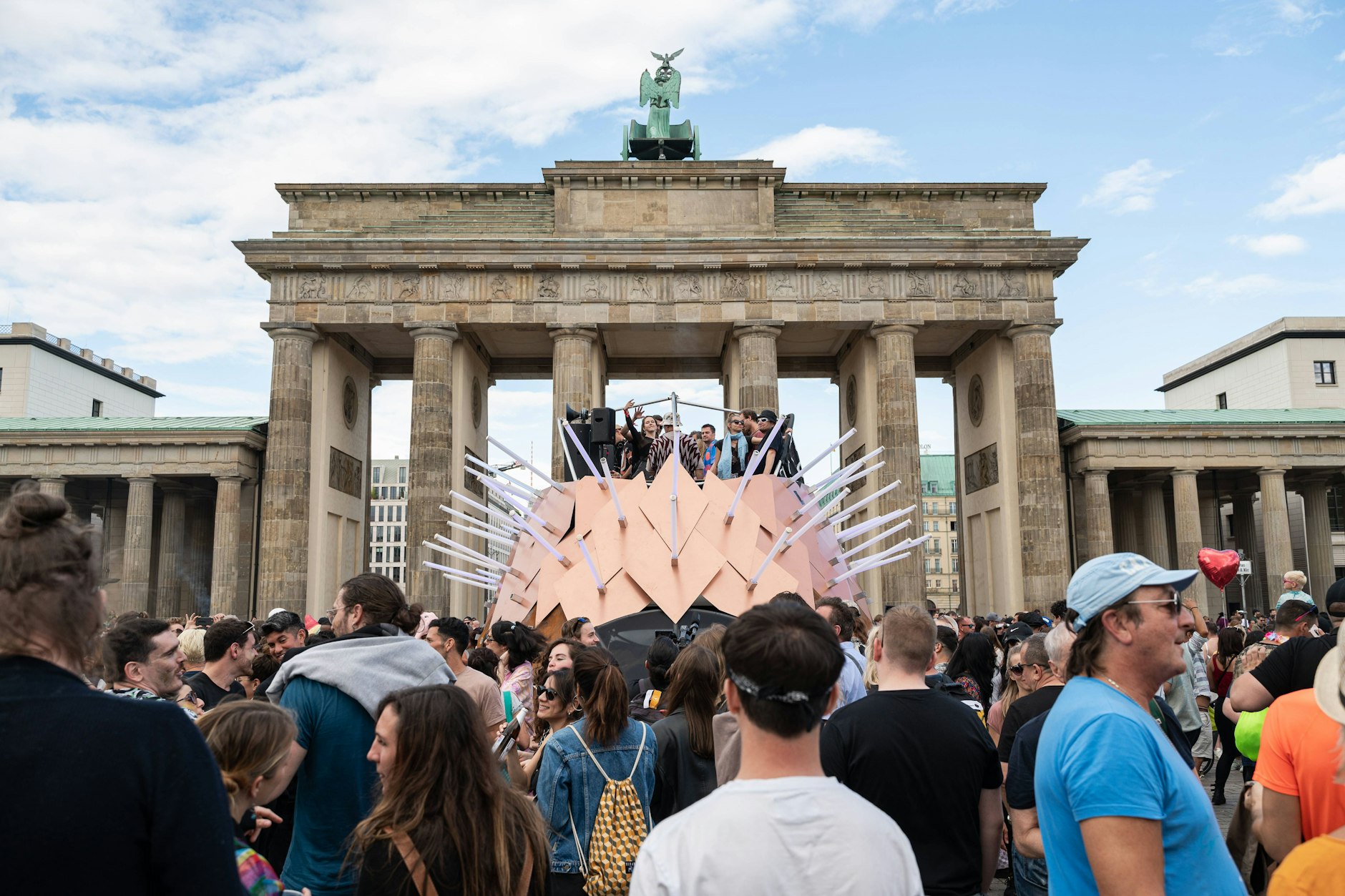 Feiernde vor dem Brandenburg Tor auf der Techno-Parade Rave the Planet im Jahr 2022.