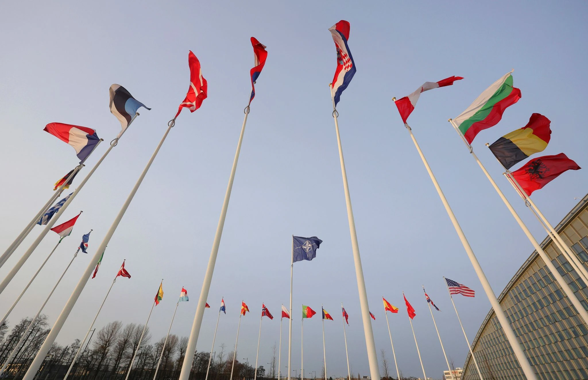 ARCHIV - Die Flaggen der NATO-Mitglieder wehen vor der Unterzeichnung einer gemeinsamen Erklärung zur Zusammenarbeit in strategischen Bereichen zwischen der NATO und der EU vor dem NATO-Hauptquartier.  