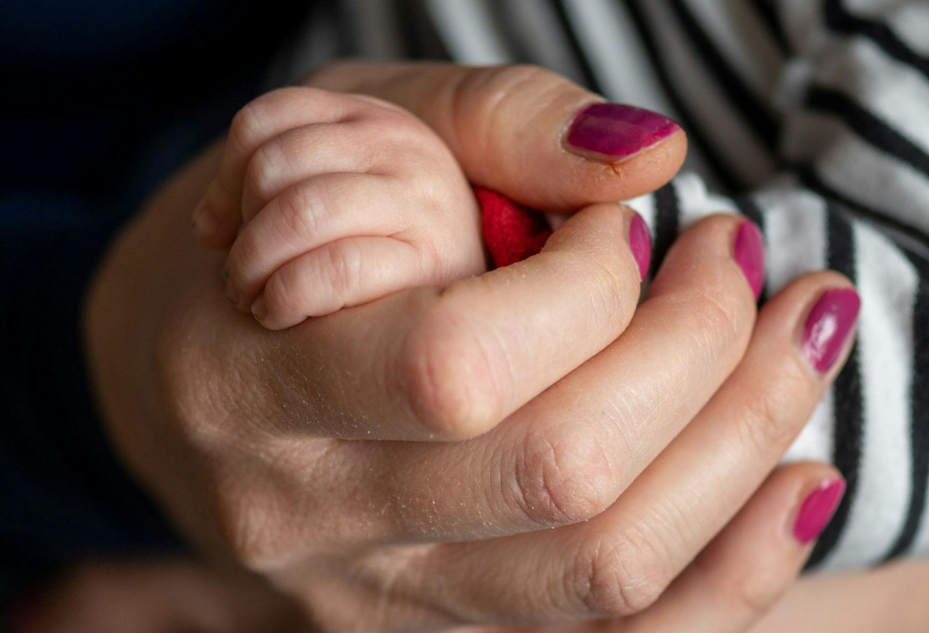 ARCHIV - Eine Mutter hält die Hand ihres Sohnes.