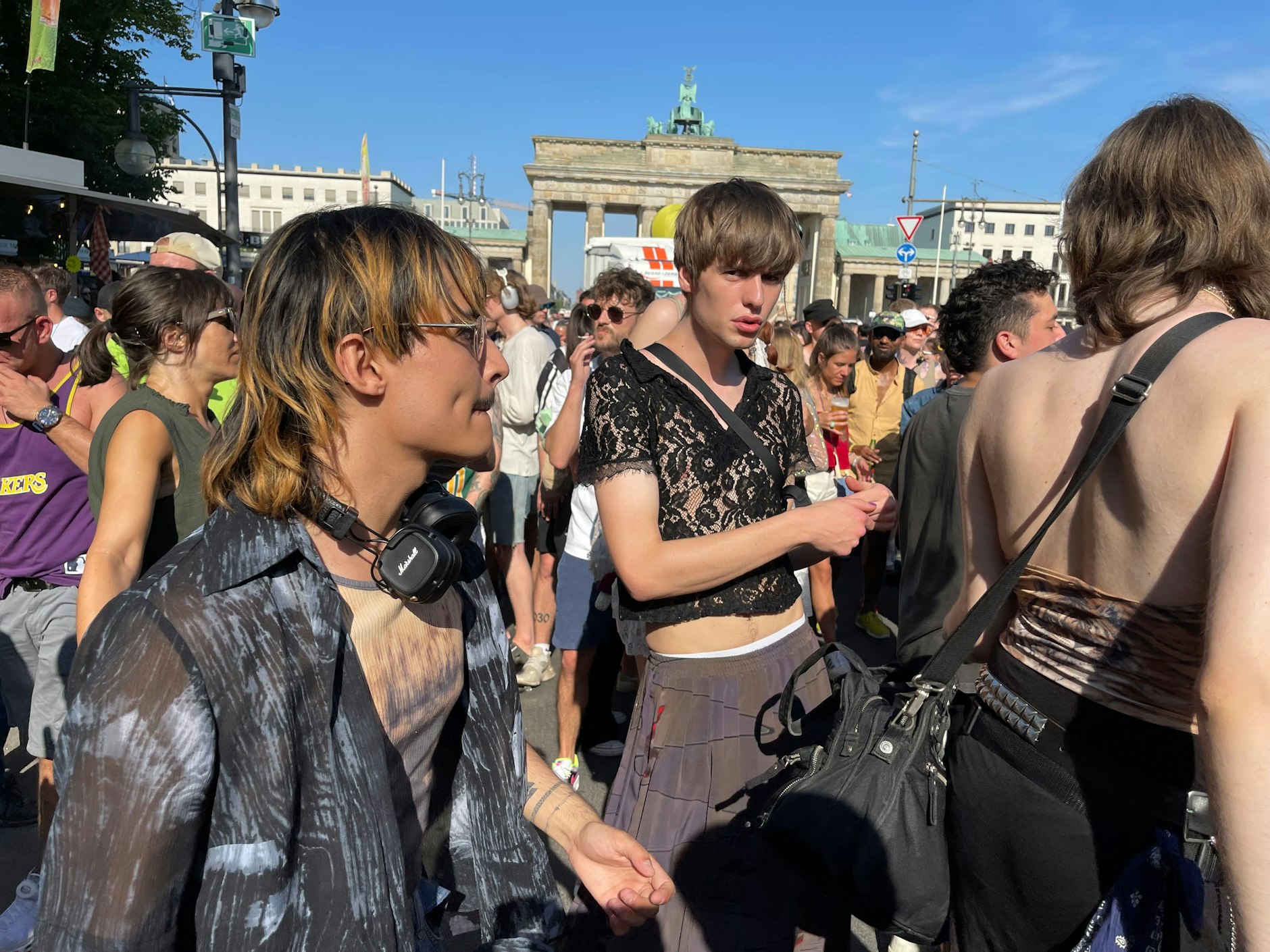 Bauchfrei-Trend und Trendfrisur: Cropped-Top aus Spitze mittig und zweifarbiger Vokuhila vorne links.