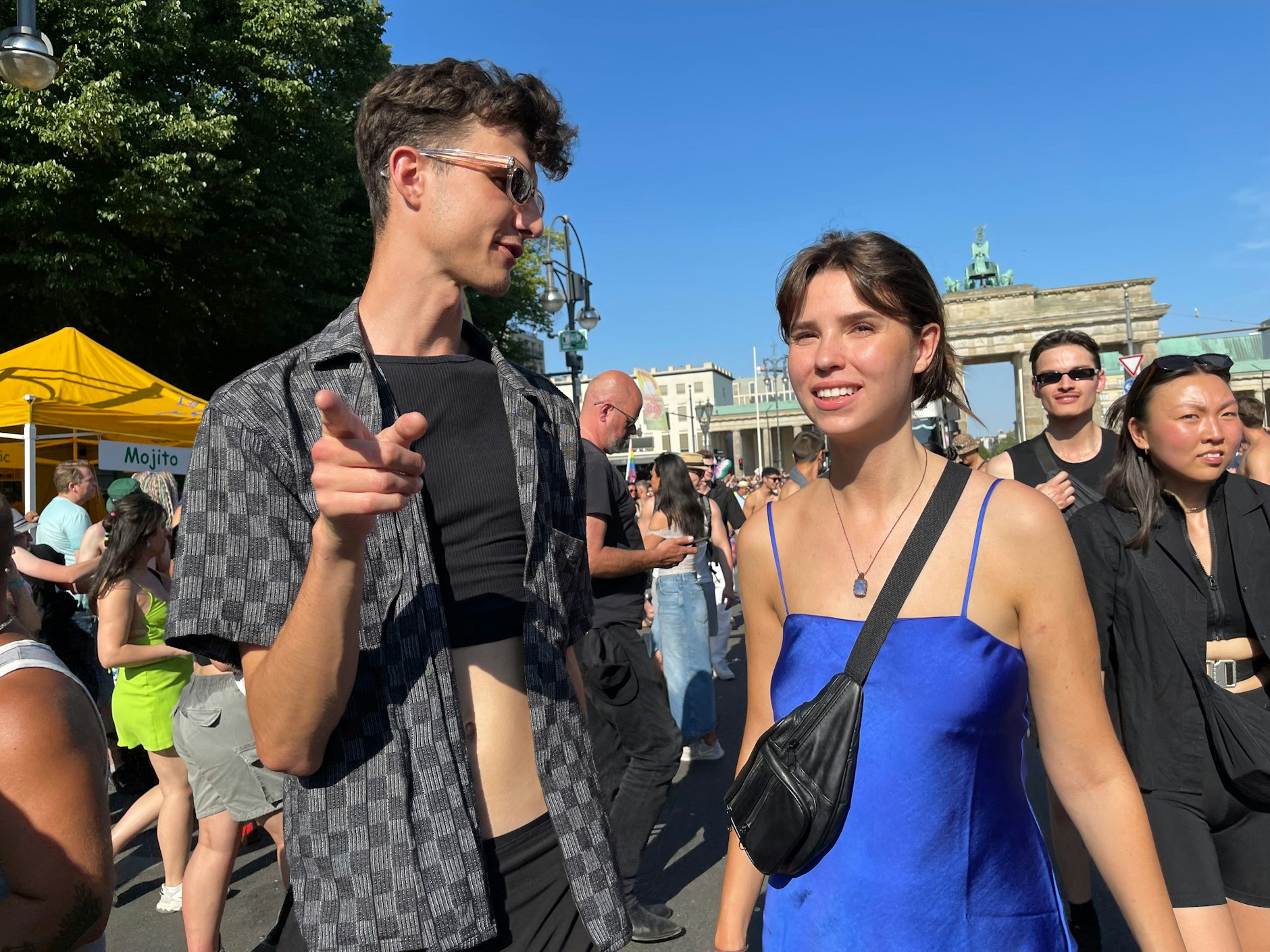 Links ein kariertes Hemd mit Cropped-Top darunter, rechts ein seidig schimmerndes Kleid in Blau