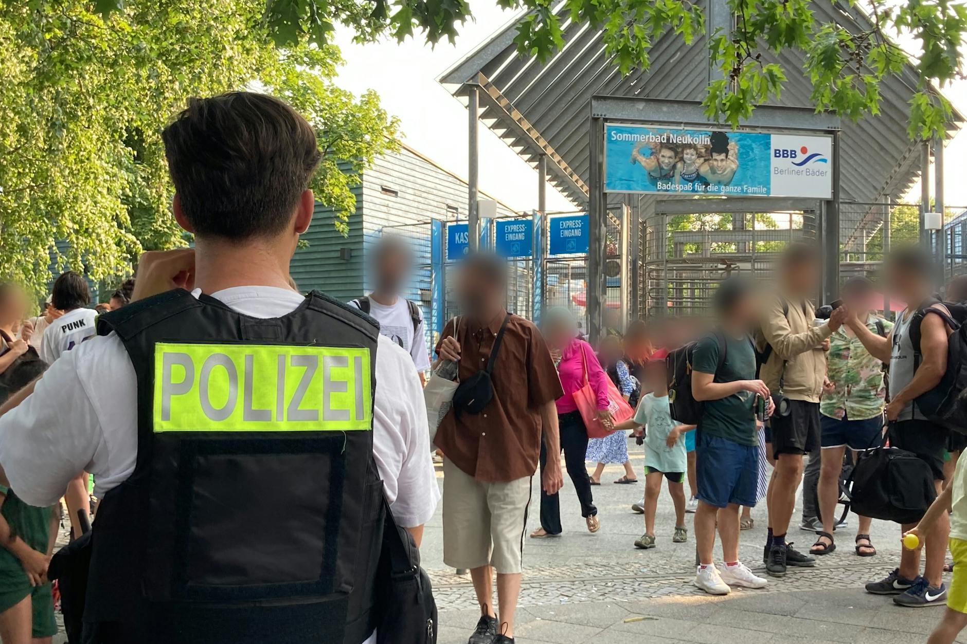 Polizisten stehen vor dem Eingang des Sommerbad in Neukölln. Sie mussten bei der Räumung des Freibades helfen.