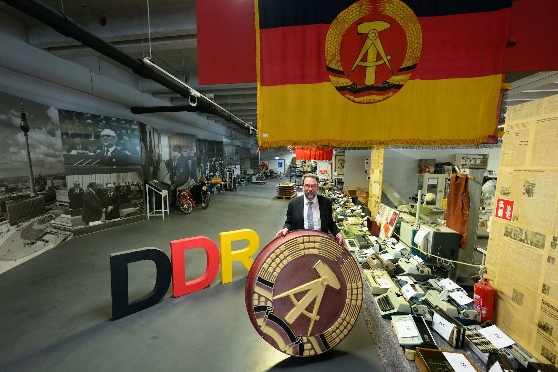 Auktionator Stefan Günther mit DDR-Emblem im DDR-Museum am Dresdner Albertplatz.