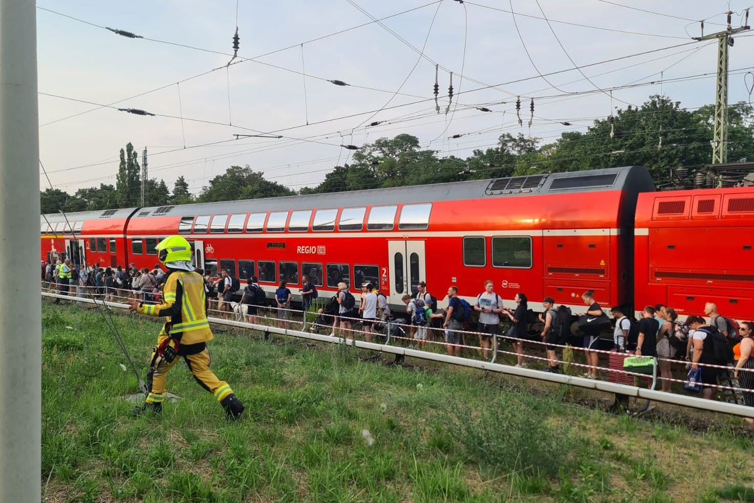 Fahrgäste stehen in der Nähe des S-Bahnhofs Birkenwerder (Landkreis Oberhavel) neben dem Zug. Ein Regionalzug der Deutschen Bahn ist am Abend wegen eines technischen Defekts stehen geblieben. Einige Reisende verließen eigenständig den Zug und liefen auf die Gleise.