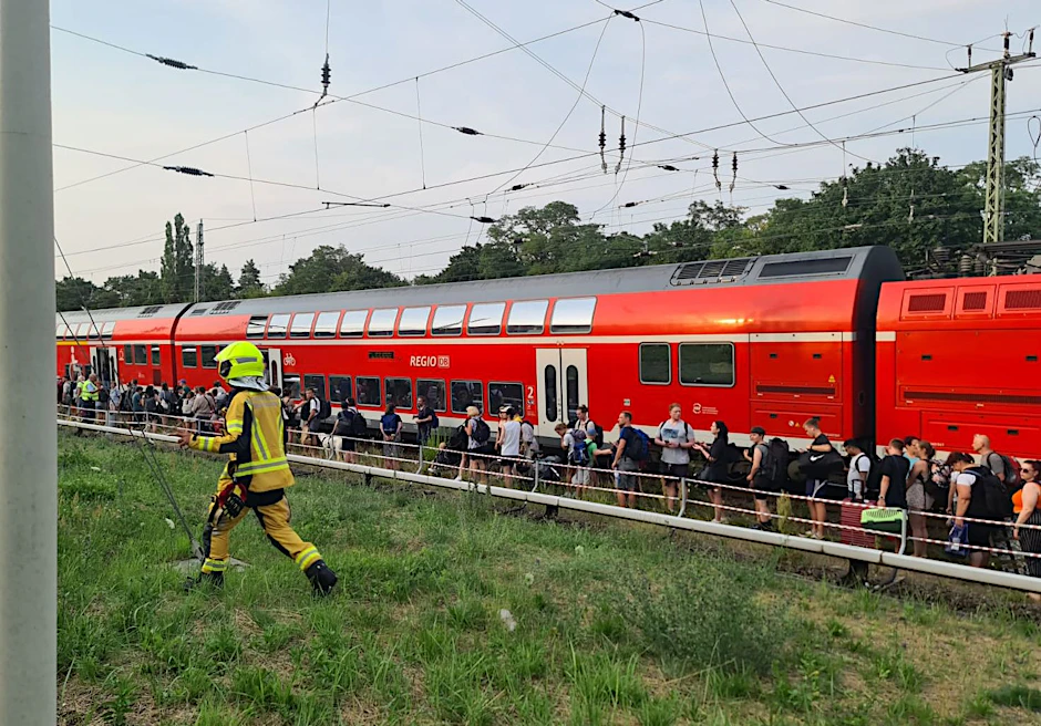 Fahrgäste stehen in der Nähe des S-Bahnhofs Birkenwerder (Landkreis Oberhavel) neben dem Zug. Ein Regionalzug der Deutschen Bahn ist am Abend wegen eines technischen Defekts stehen geblieben. Einige Reisende verließen eigenständig den Zug und liefen auf die Gleise.