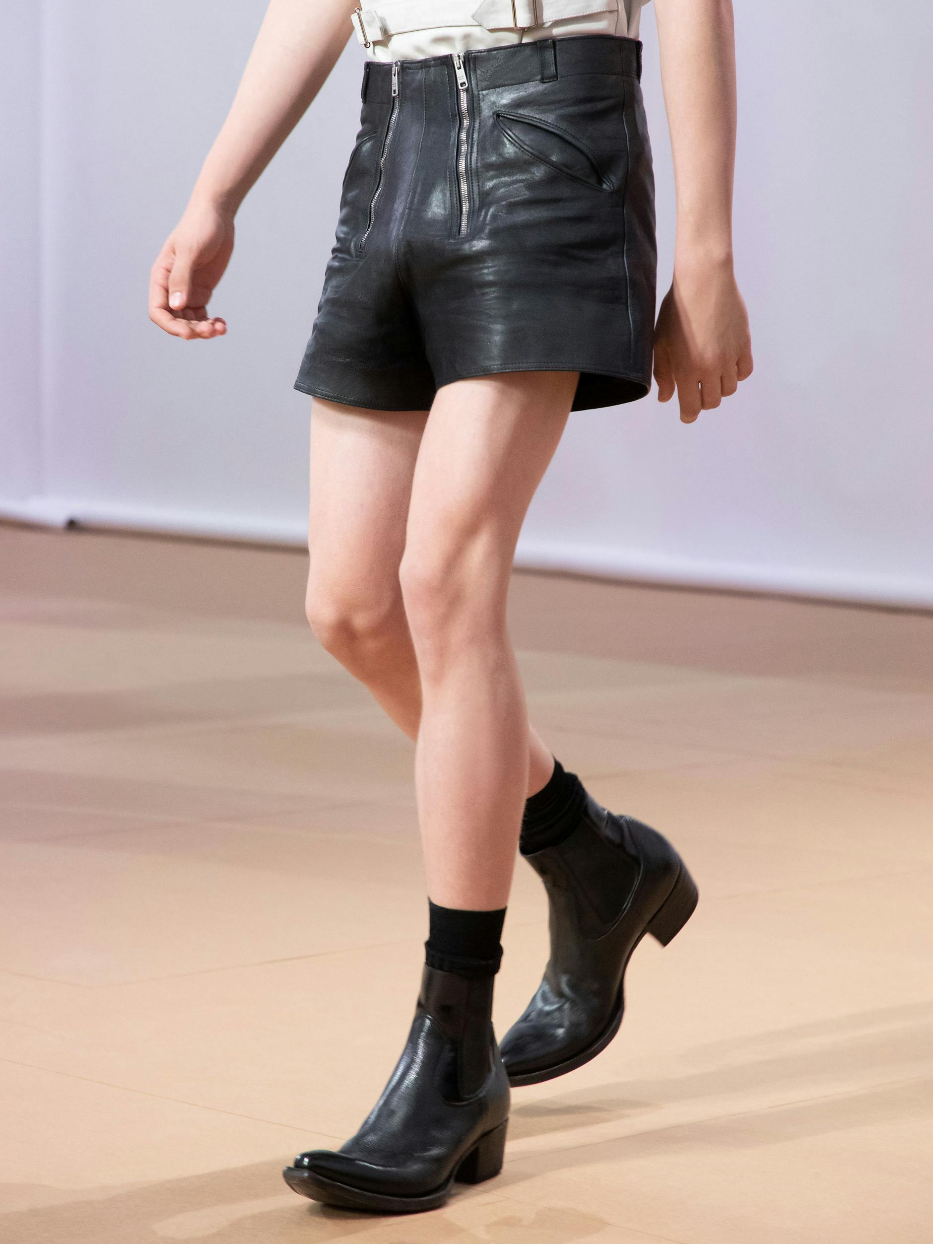 Prada kreiert für diesen Sommer eine interessante Mischung aus Cowboy-Boot und Stiefelette für den Mann. Auf dem Runway wurde sie mit Ledershorts kombiniert. Die sogenannten Leather Booties kosten 1350 Euro.