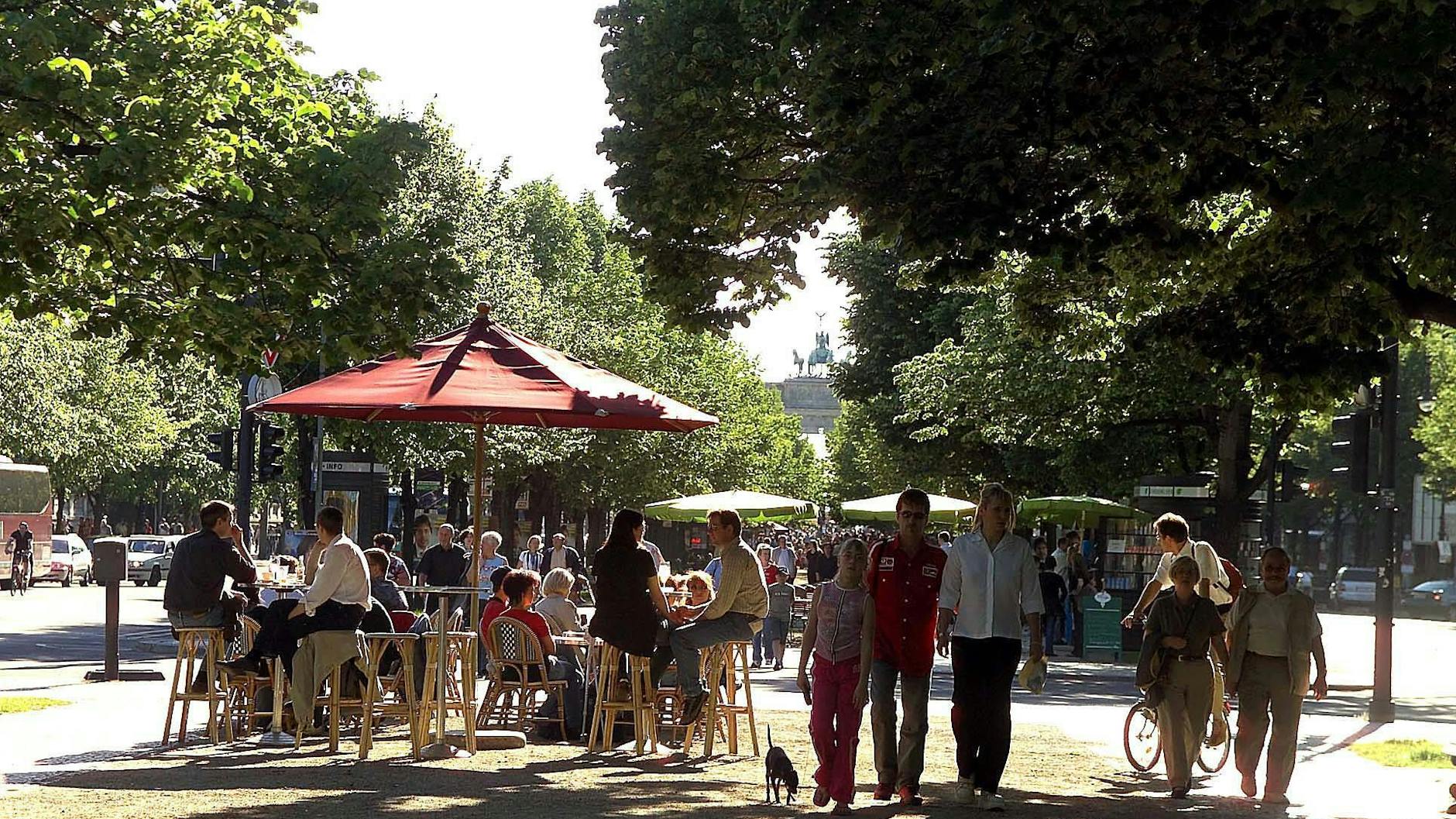 Flanieren auf der Straße Unter den Linden in Berlin. Im Schatten ist es schön kühl.