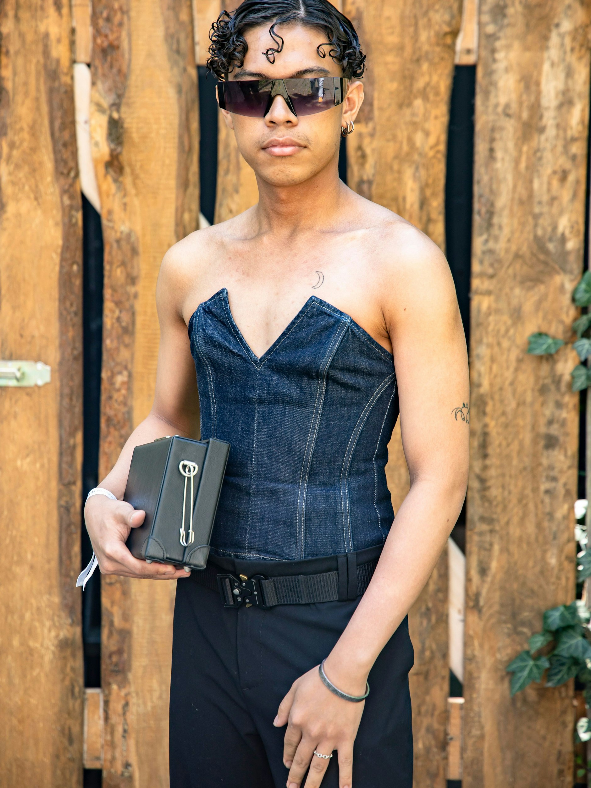 Gleich mehrere Trends in einem Look kombiniert: Scheitelfrisuren, hier mit leicht versetzter Mitte, sind genauso angesagt wie Korsetts und prägnante Linienführung. Auch dunkler Denim-Stoff ist aktuell ein großes Modethema. Also alles richtig gemacht.