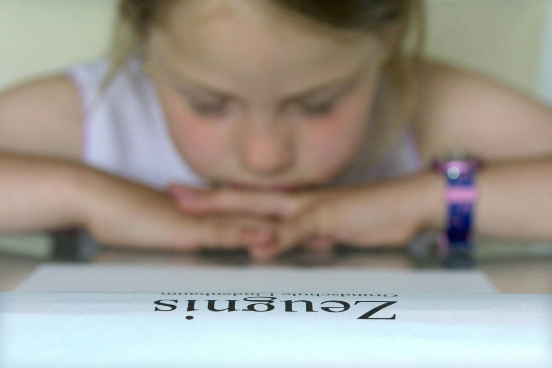 Ein Mädchen begutachtet ihr Zeugnis.