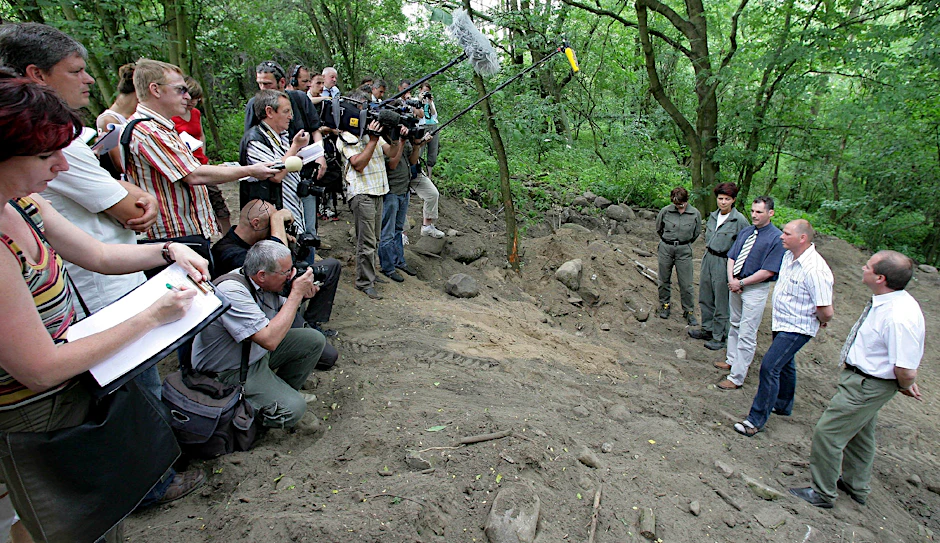 Die Ermittler, darunter auch Michael Halbach (blaues Hemd, Schlips), zeigen Mitte Juni 2006 Journalisten die Stelle in einem Waldstück in Lossow, an der die Leichen gefunden wurden.
