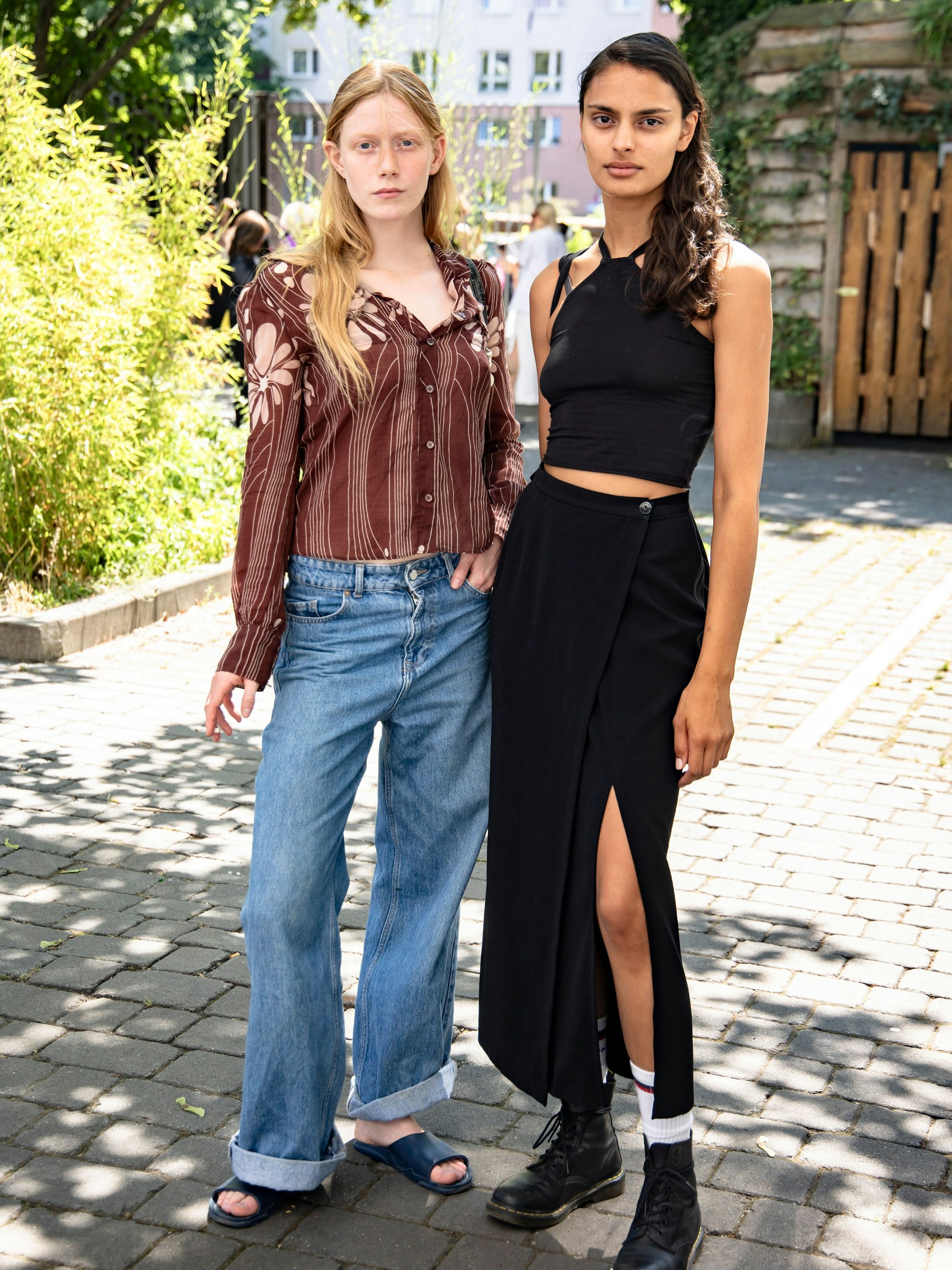 Eben noch auf dem Laufsteg, jetzt vor unserer Street-Style-Kamera: Am Rande der Modenschau des Labels Litovska im Kraftwerk beweisen diese beiden Models, dass lässige Kombinationen aus Jeans und Hemd beziehungsweise Rock und Crop-Top immer gehen.