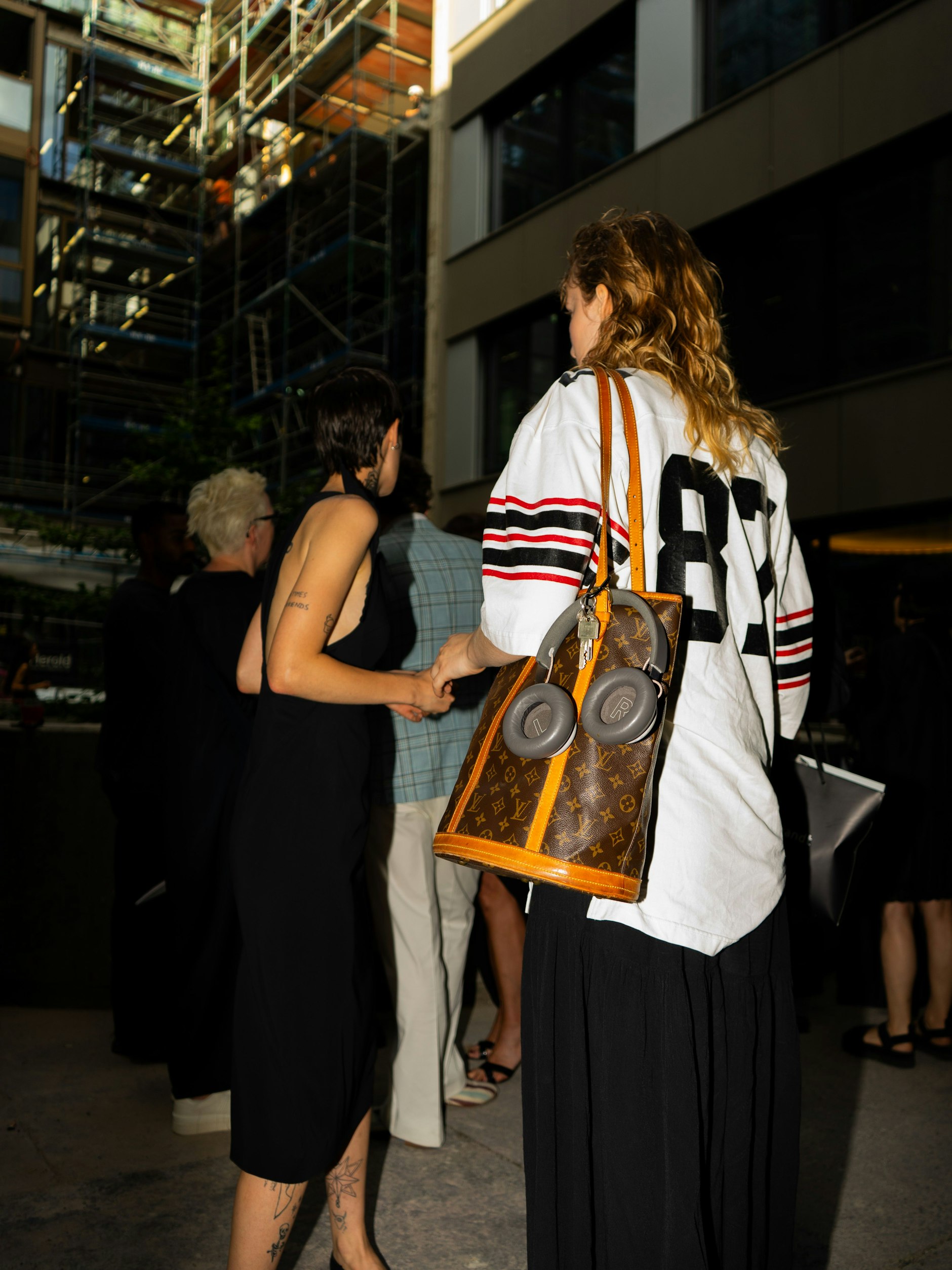 Baseballshirt, Kopfhörer und Shopper von Louis Vuitton: Designertaschen lassen sich eben auch sportlich kombinieren.