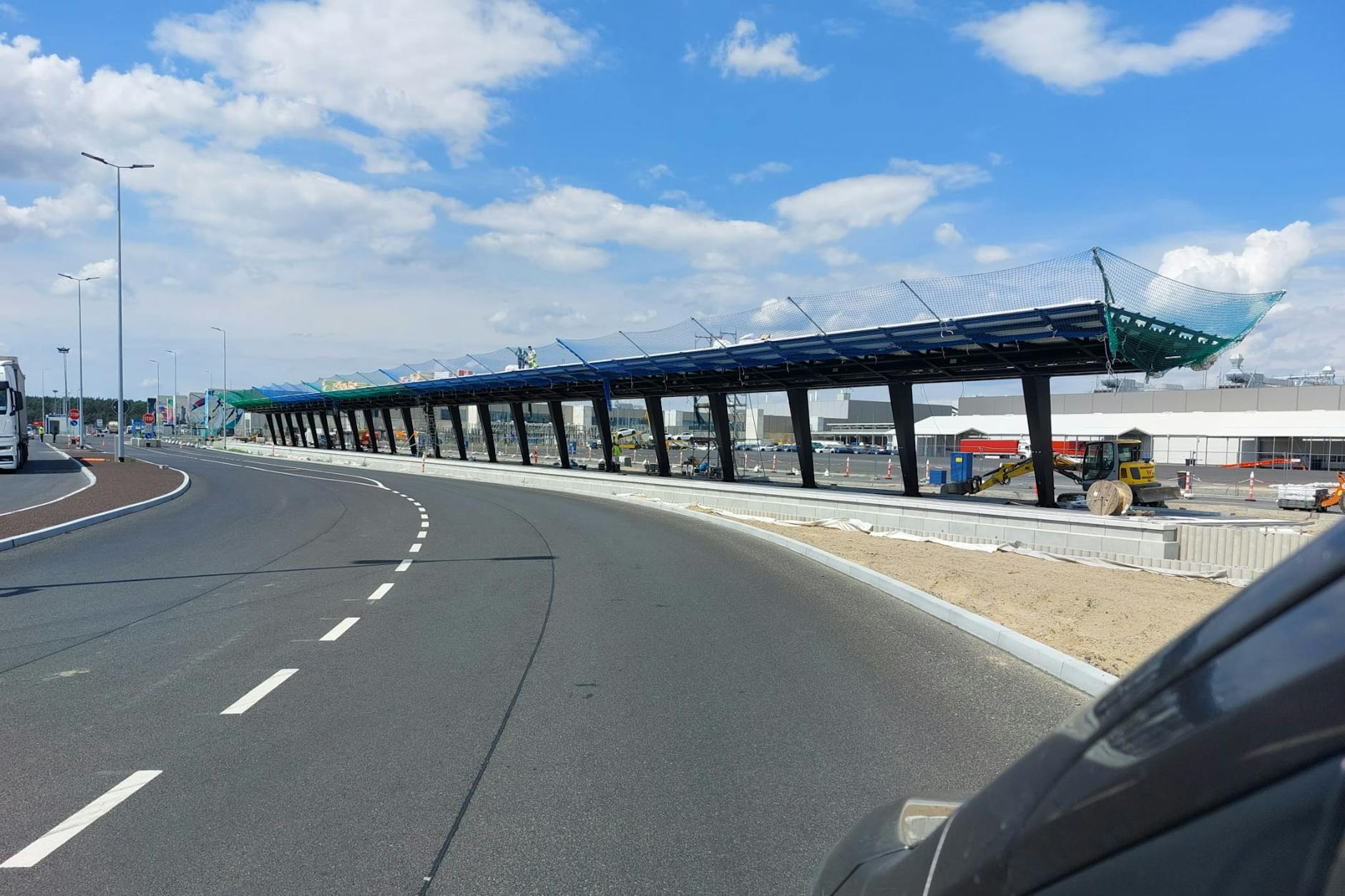 Hier entsteht der Bahnhof Tesla Süd. Die Dachstützen stehen, das Dach ist montiert. Nebenan werden Gleise verlegt. Nun zeichnet sich ab, wann hier erstmals ein Zug aus Erkner eintrifft.