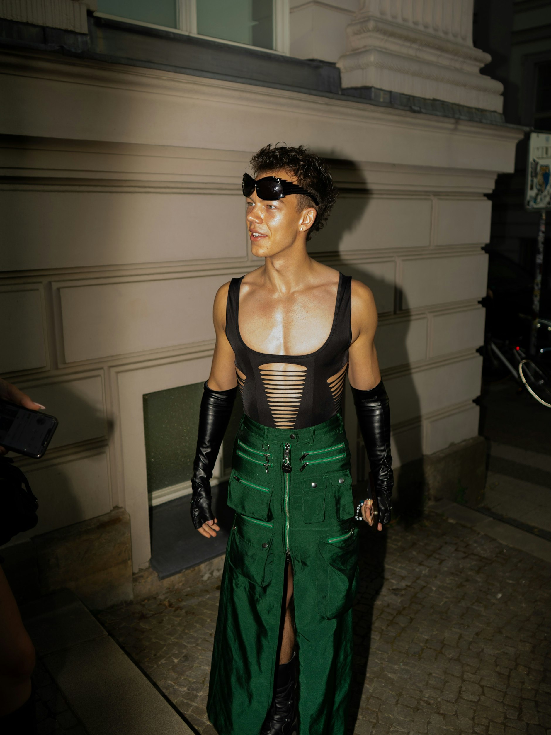 Lederartige Stulpen, gerippter Body, ein Vintage-Rock von Diesel: Max Uhrmacher ist Gast der Namilia-Show und auf jeden Fall gekommen, um aufzufallen. Als das Model die Outfits der anderen sieht, sagt es: „Da hätte ich mich ja noch mehr aufstylen können.“