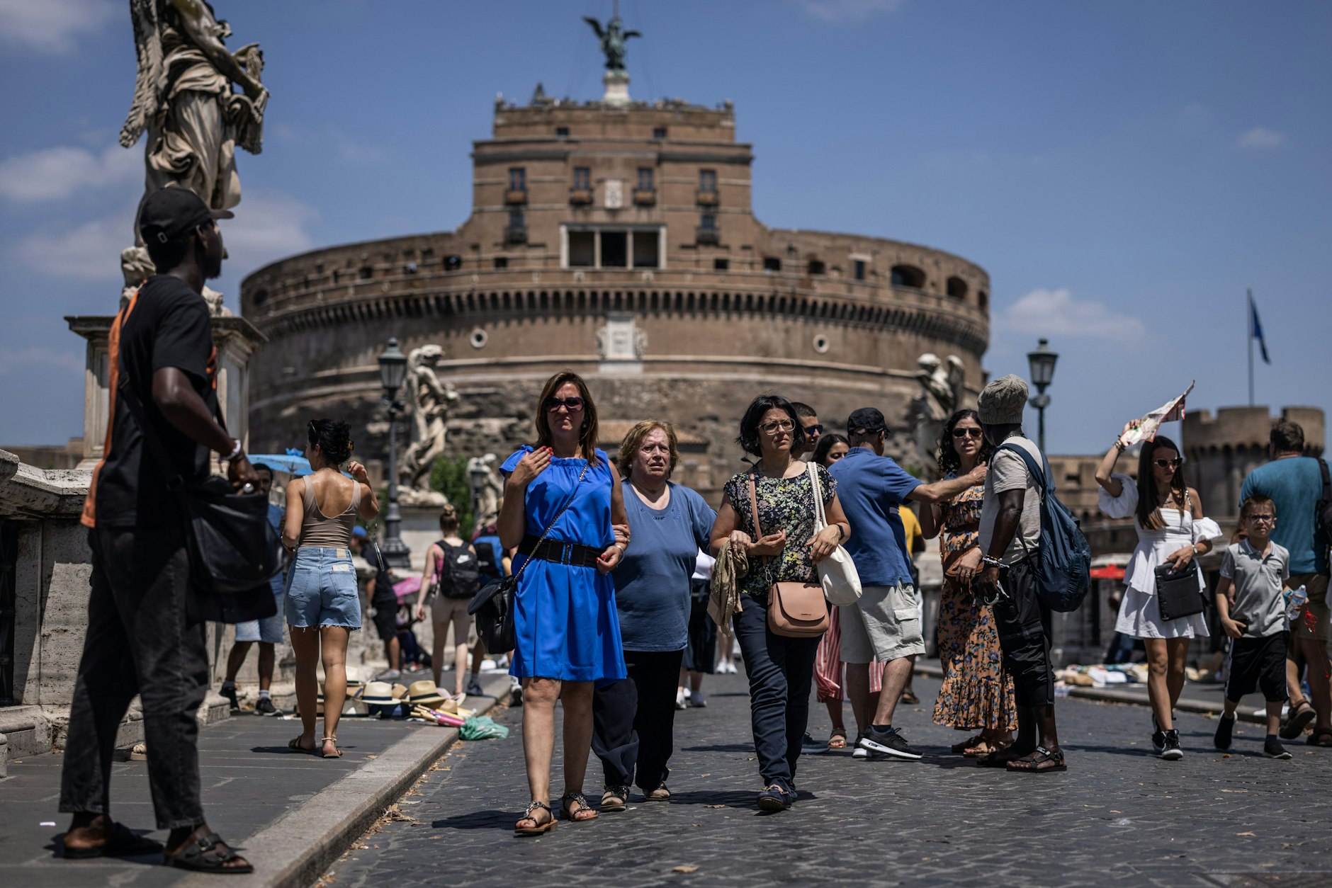 Besucher überqueren die Ponte Sant Angelo bei warmen sommerlichen Temperaturen in der italienischen Hauptstadt.