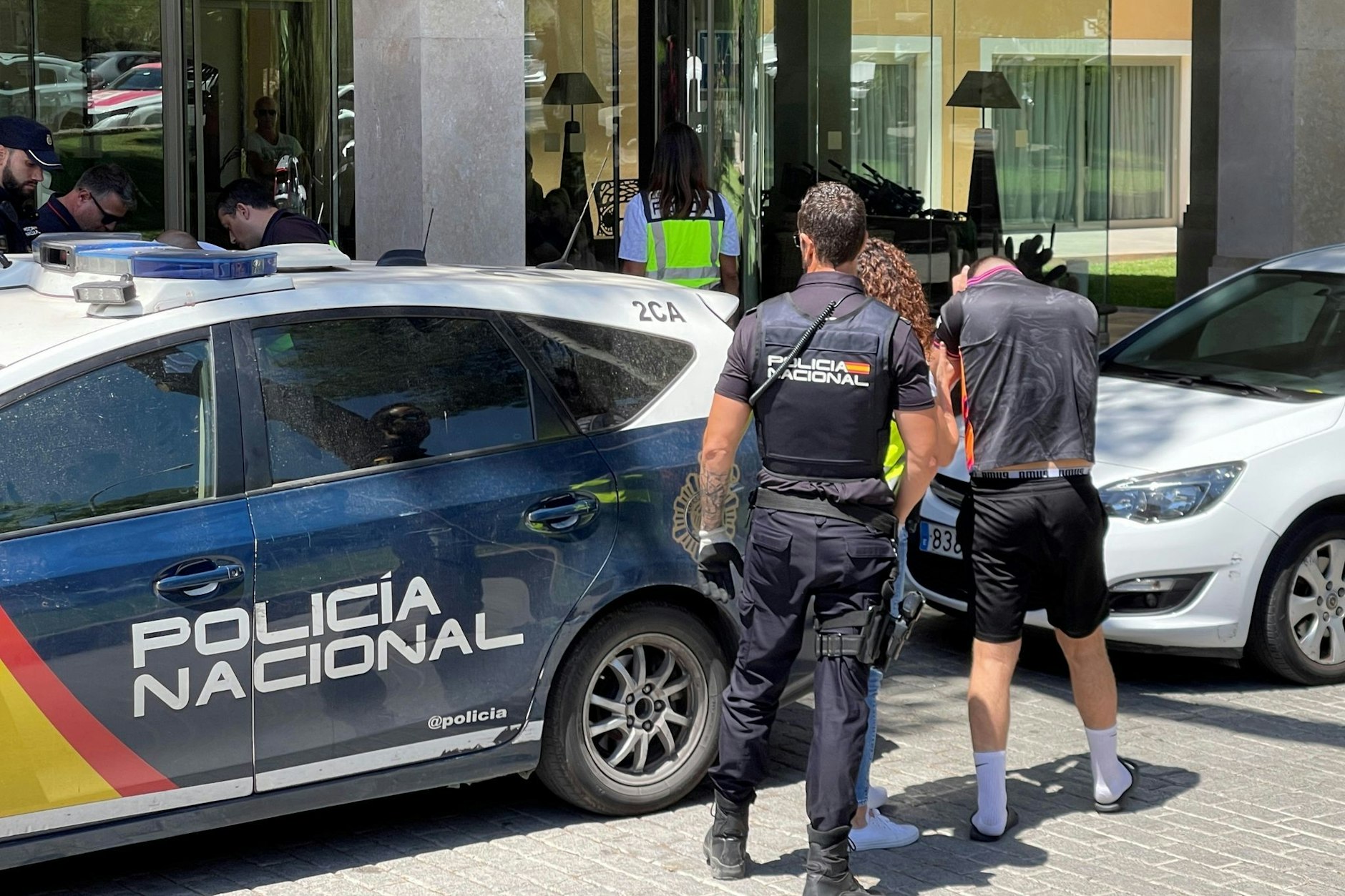 Ein Verdächtiger wird von der Polizei zu einem Hotel gebracht.