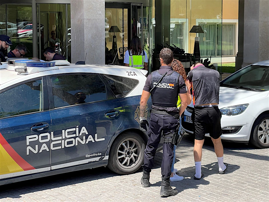 Ein Verdächtiger wird von der Polizei zu einem Hotel gebracht.