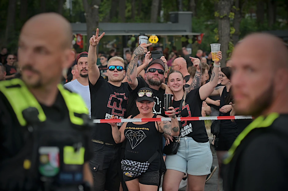 Rammstein-Fans und Demonstranten werden mit Absperrband voneinander getrennt. Es sind immer wieder Mittelfinger zu sehen und Beleidigungen zu hören.