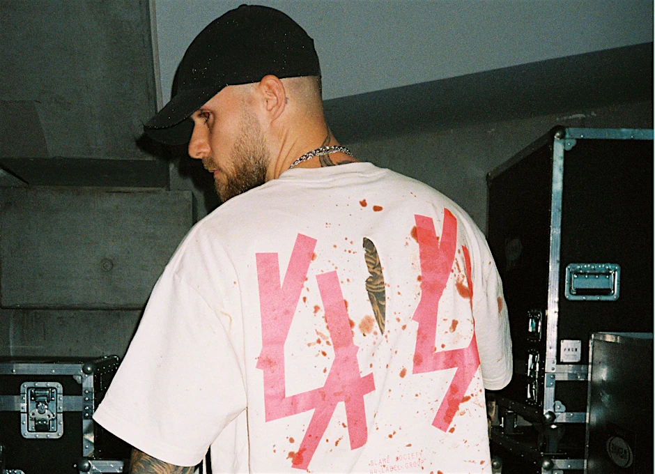 Max Kobosil in einem mit Kunstblut bespritzten T-Shirt seiner Marke 44 Label Group im Backstage des Velodrom. Kurz nach 1 Uhr kam er in Berlin an, um für einige Stunden aufzulegen, den ersten Gig der Nacht hatte er in Nürnberg absolviert.