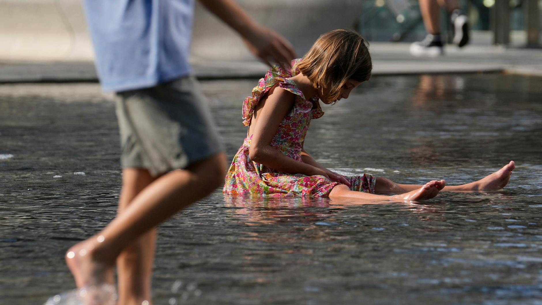Italien: Kinder erfrischen sich in einem Brunnen. Die Temperaturen erreichten in einigen Teilen des Landes bis zu 42 Grad Celsius.