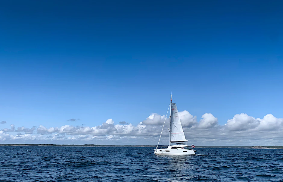 Ein Katamaran fährt bei sonnigem Wetter über die Ostsee.