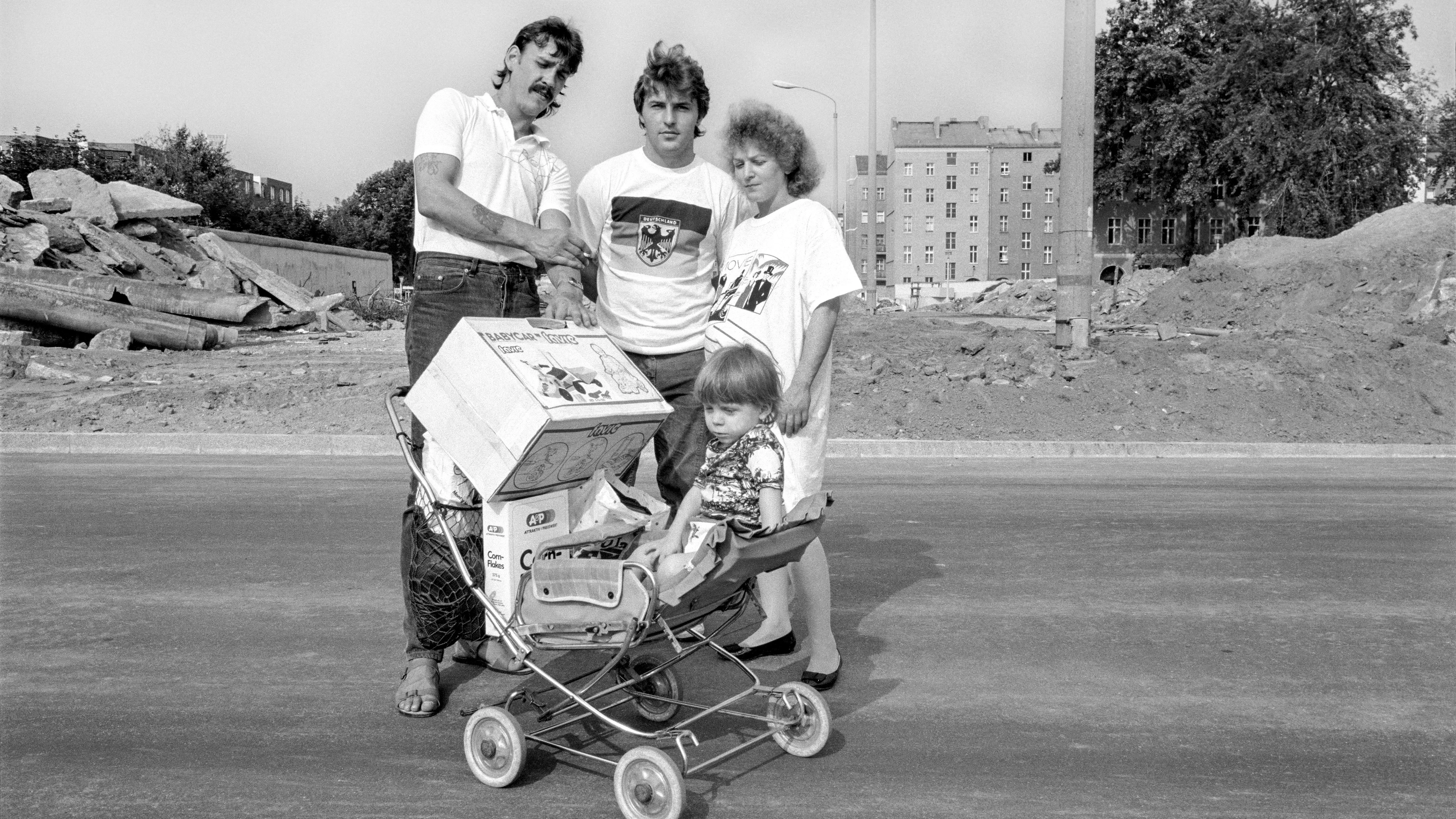 „Na klar, das wird jetzt erst mal hart für uns. Aber da müssen die Deutschen jetzt eben alle zusammenhalten.“ Eine Familie aus der DDR im Grenzstreifen in Berlin.&nbsp;