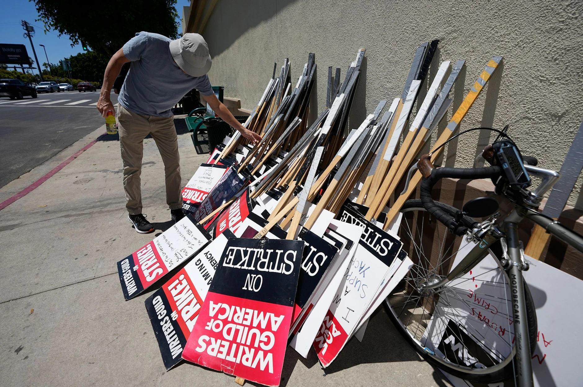 Ein Demonstrant wählt während einer Kundgebung in Los Angeles sein Schild zum Streiken aus.  