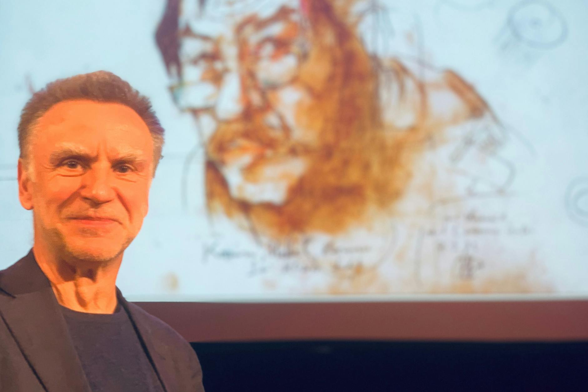 Dieter Stolz bei einer Veranstaltung in Telgte vor einem Günter-Grass-Porträt von Horst Janssen.