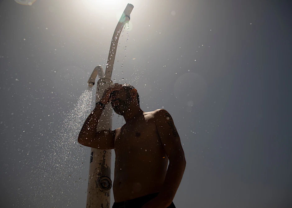 Ein Mann duscht sich bei heißen Temperaturen am Strand von&nbsp;S’Arenal ab. Der Höhepunkt der dritten Hitzewelle in Spanien bringt Einheimische und Touristen ins Schwitzen.