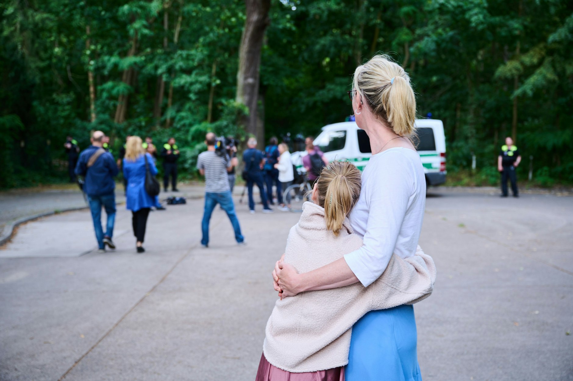 Kleinmachnow: Eine Anwohnerin und ihre Tochter sehen dem Treiben von Journalisten und Polizei zu.