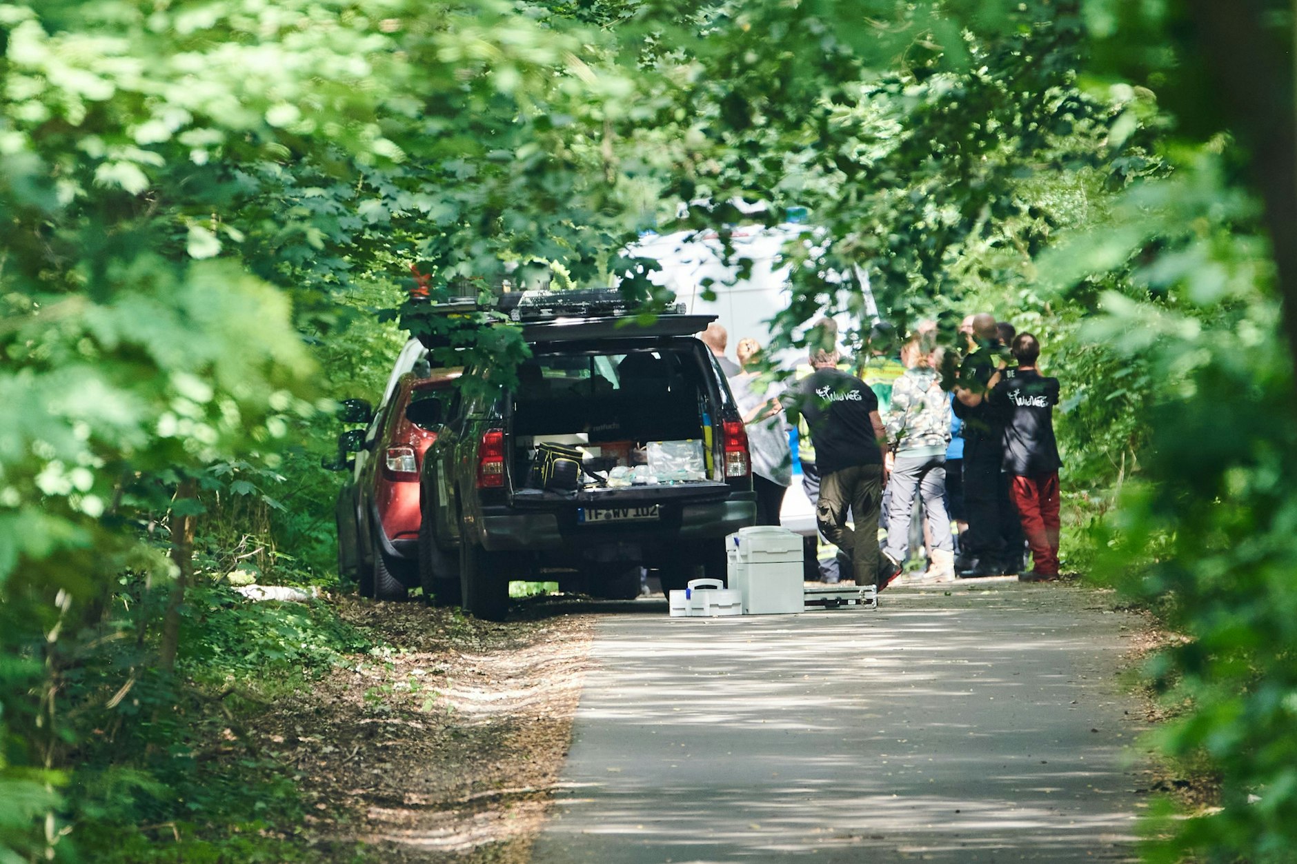  Tierexperten und Polizeibeamte stehen in einem Waldgebiet in Zehlendorf. 