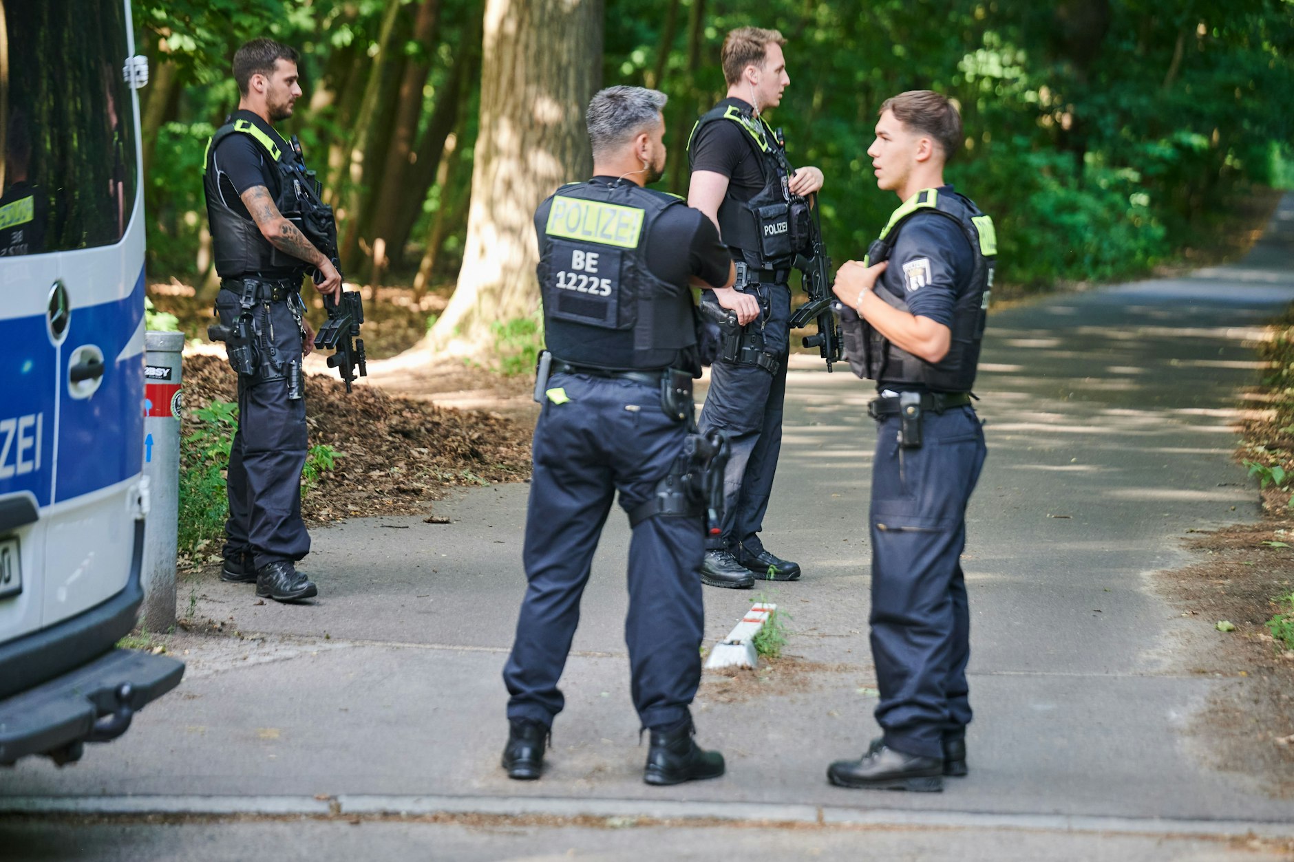 Polizisten stehen am Eingang eines Waldgebiets in Berlin-Zehlendorf.