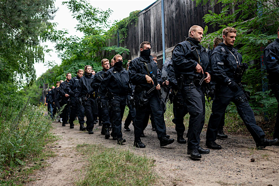 Polizisten laufen im Bereich der südlichen Landesgrenze von Berlin durch Kleinmachnow.