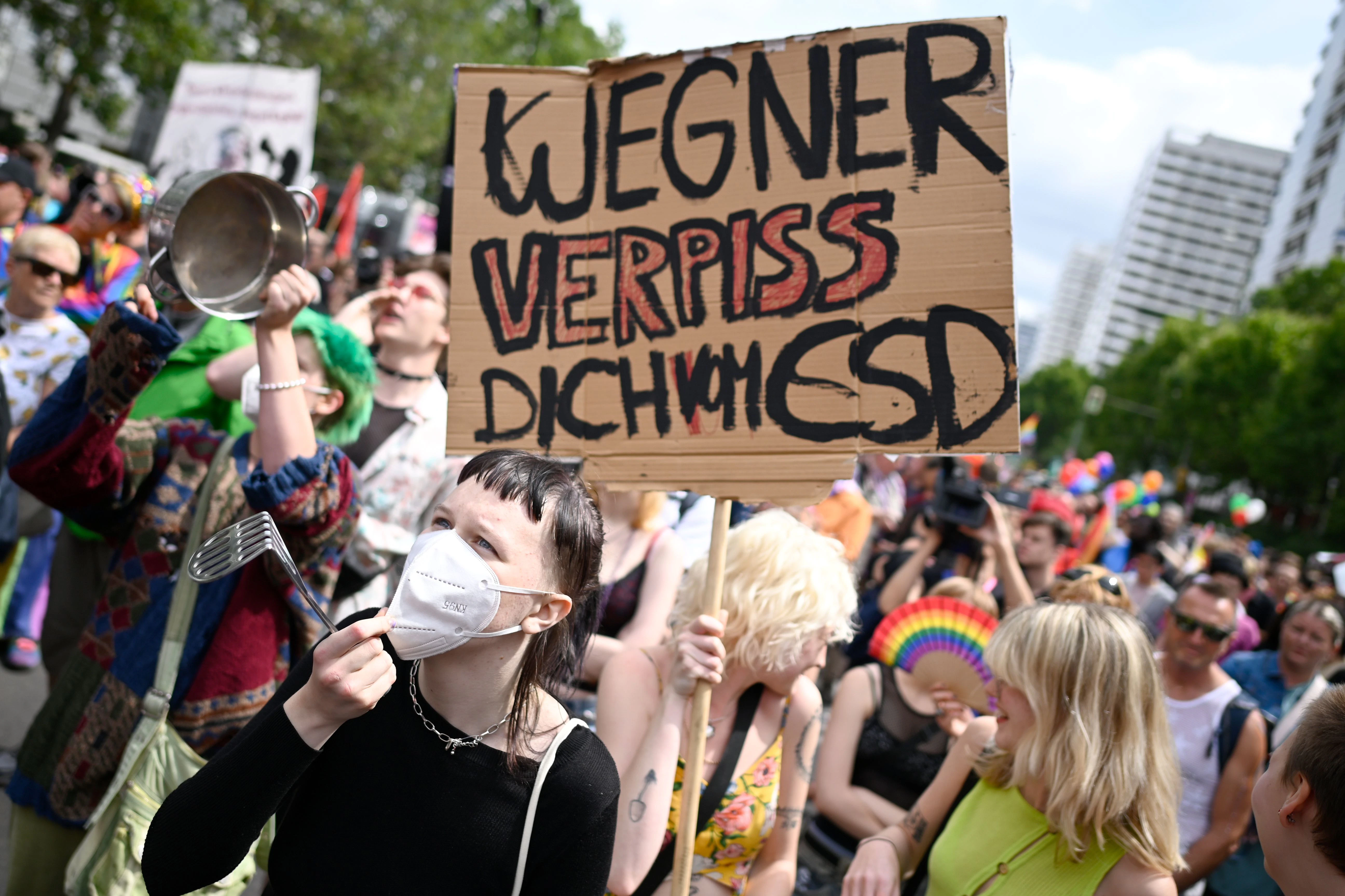 „Wegner verpiss dich vom CSD“ steht auf dem Schild einer Frau, die bei der Rede von Kai Wegner bei der 45. Berlin Pride-Parade laut protestieren.