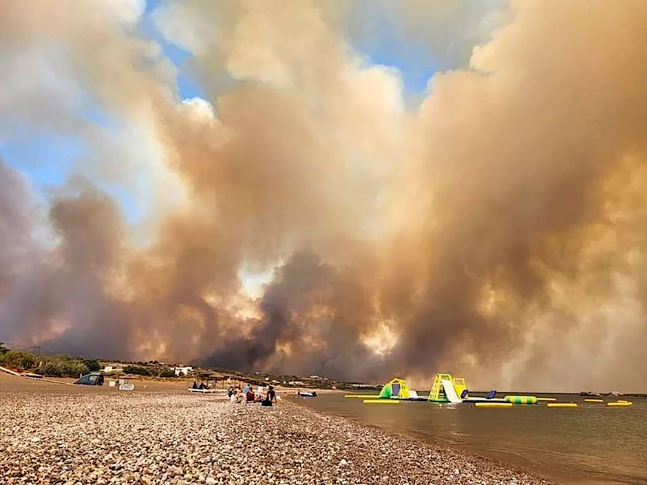 Dichte Rauchwolken eines Waldbrandes steigen auf der griechischen Insel Rhodos in den Himmel. Wegen eines Großbrandes haben die Behörden die Evakuierung von vier Orten, darunter zwei Badeorte, angeordnet.&nbsp;&nbsp;