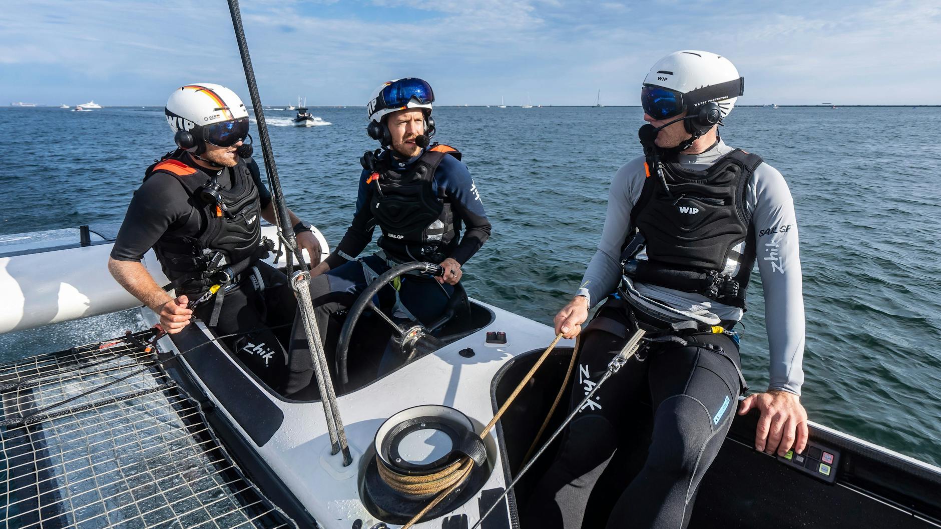 Sebastian Vettel (M) mit dem Skipper Erik Heil (l.) und Stuart Bithell