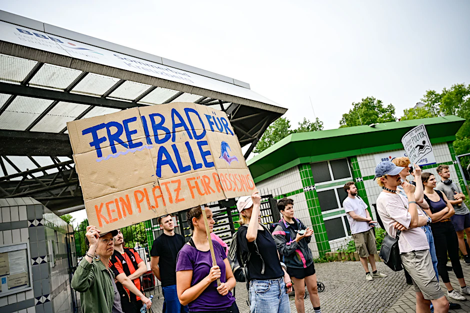 Die Menschen auf der Kundgebung vor dem Prinzenbad fordern, dass Geld in Soziales, Schwimmbadpersonal und Sanierungen von Bädern fließt – statt in mobile Polizeiwachen.