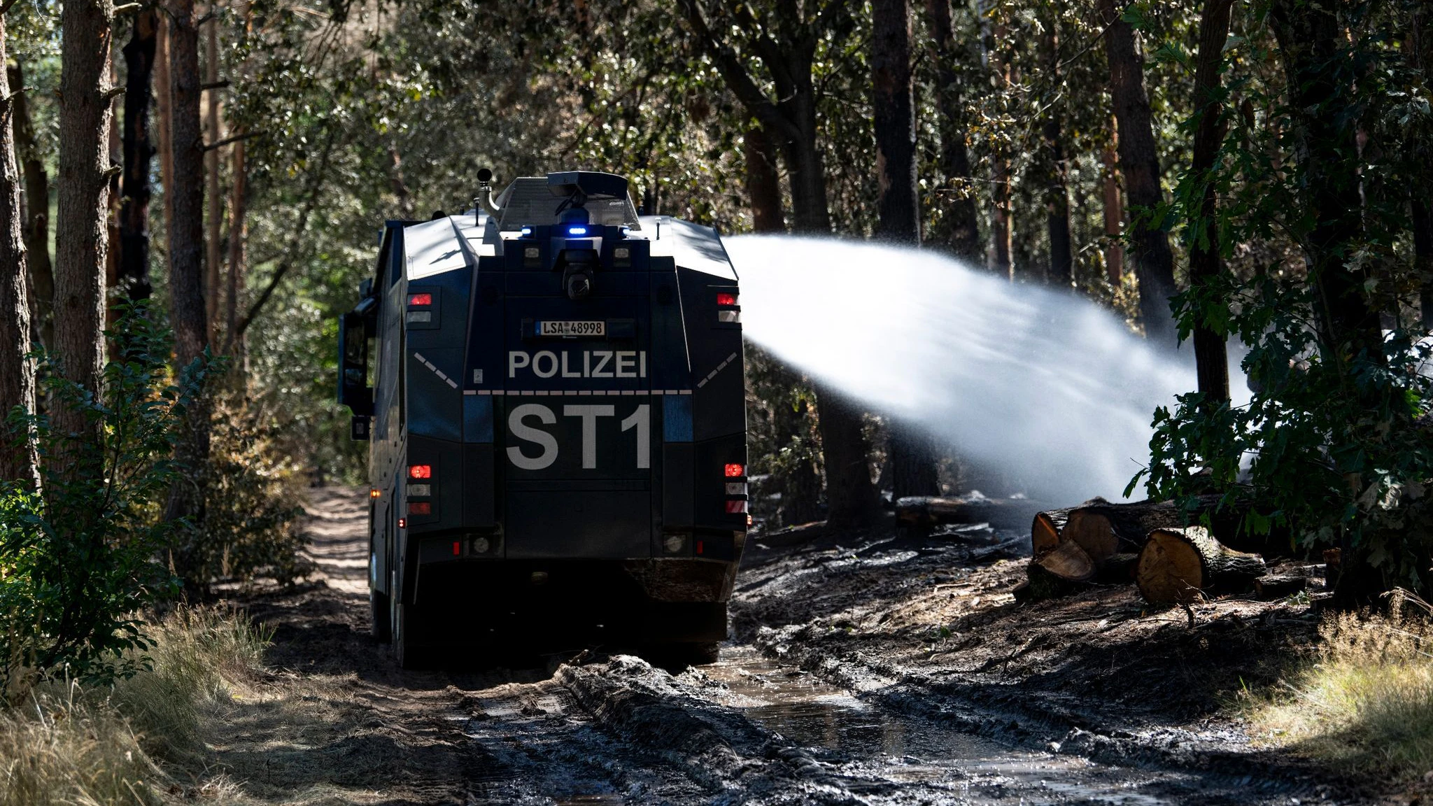 Ein Wasserwerfer löscht die Brandstelle am Sprengplatz der Berliner Polizei im Grunewald.