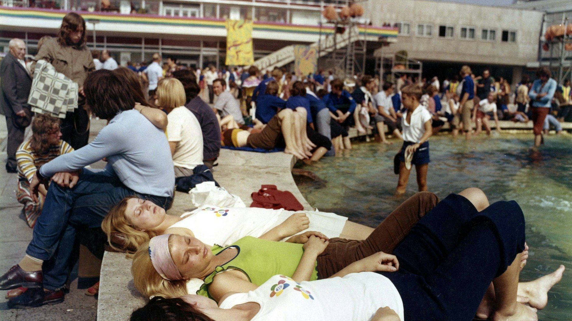 Frauen sonnen sich am Rand des Brunnens der Völkerfreundschaft auf dem Berliner Alexanderplatz während der X. Weltfestspiele der Jugend und Studenten.