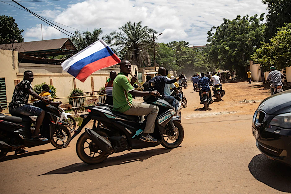 Anhänger von Hauptmann Traore schwenken in Burkinas Faso eine russische Fahne auf einem Motorrad. 