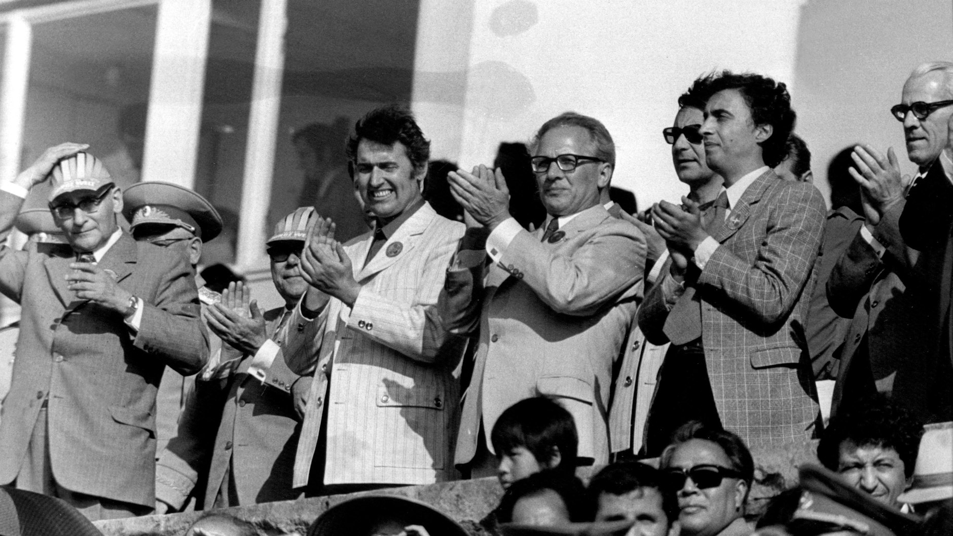 Dr. Günter Jahn, damaliger Vorsitzender des Zentralrates der FDJ (2.v.l.), der damalige SED-Vorsitzende Erich Honecker (M.) und rechts neben Honecker Roberto Viezzi, damaliger Präsident des WBDJ (Weltbund der Demokratischen Jugend), stehen auf der Ehrentribüne am Eröffnungstag. (Archivbild: 28.07.1973)