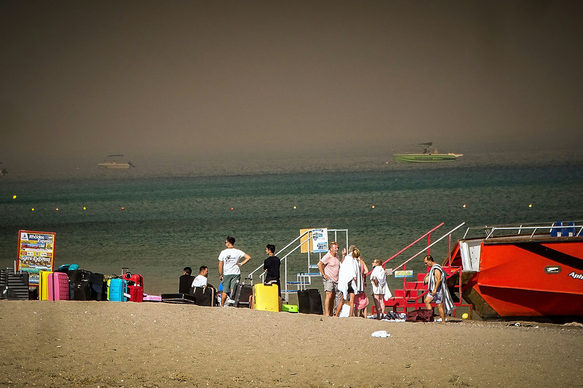 Touristen stehen an einem Strand, wohin sie wegen eines Waldbrandes auf der griechischen Insel Rhodos in Sicherheit gebracht worden sind.&nbsp;