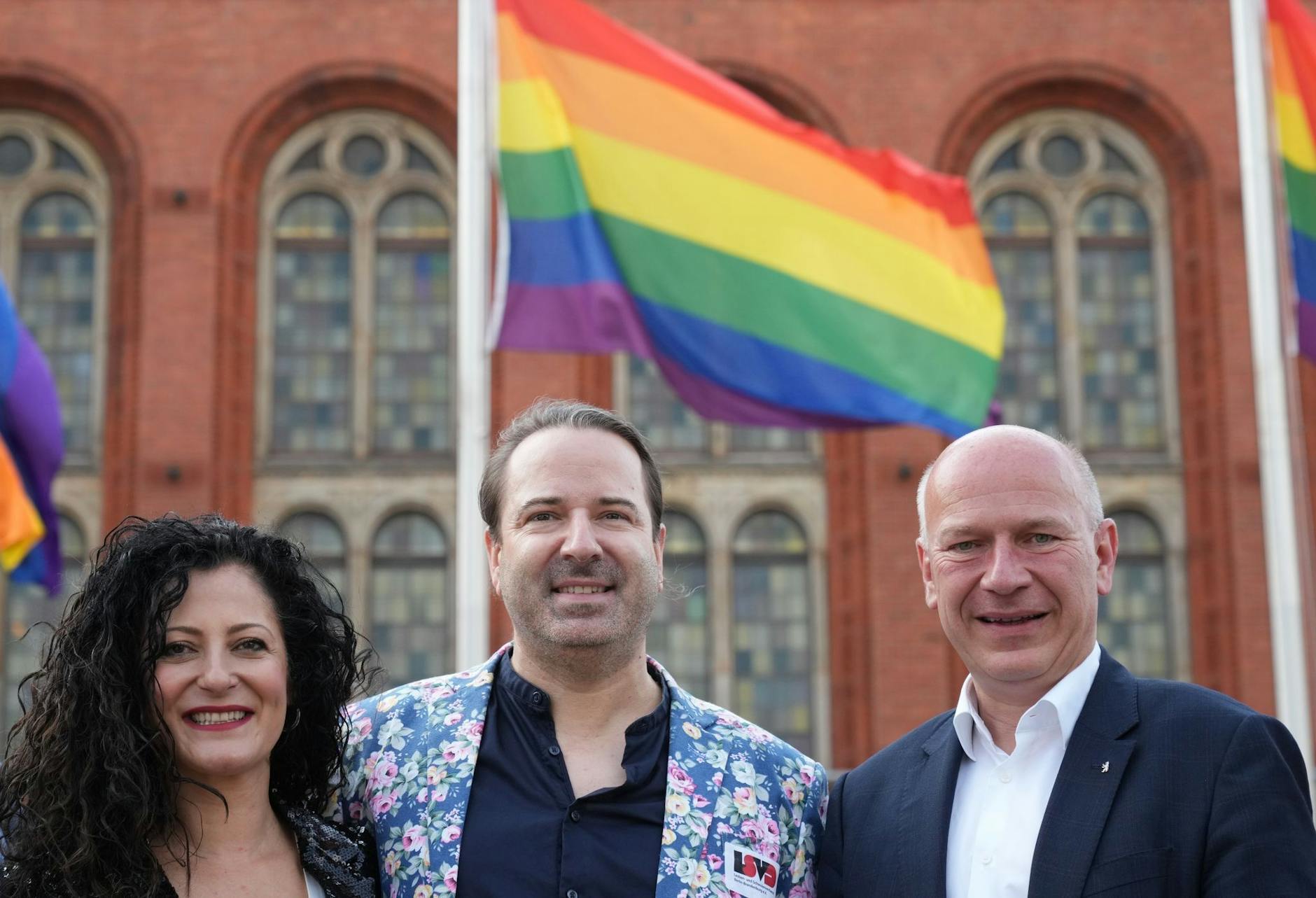 Kai Wegner (r), Alexander Scheid (M) und Cansel Kiziltepe haben gemeinsam die Regenbogenflagge vor dem Roten Rathaus gehisst.