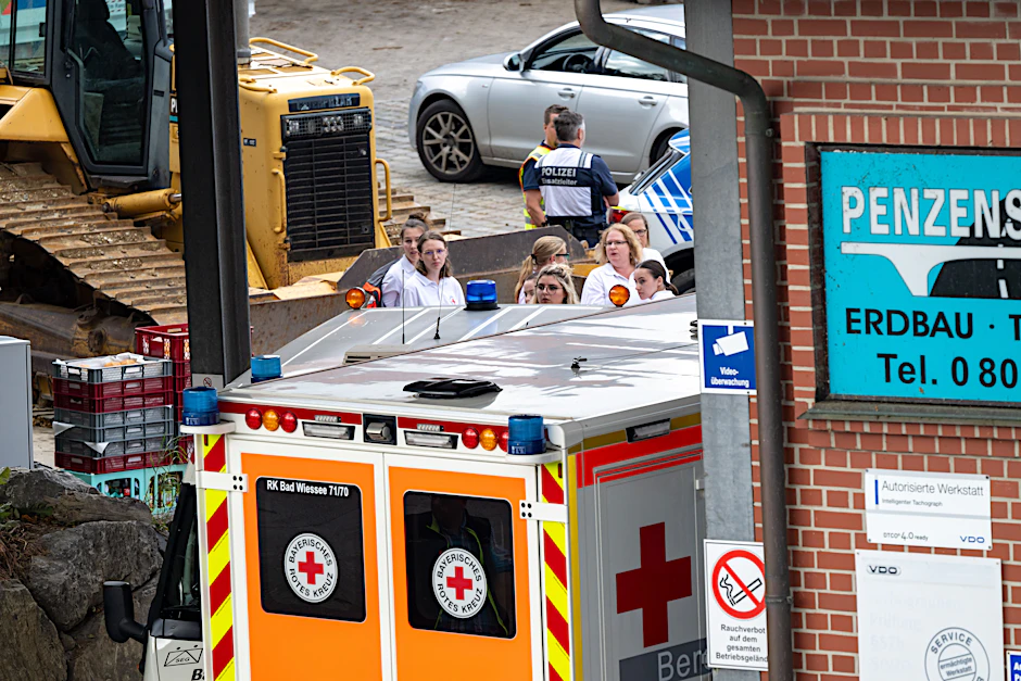 Ein Krankenwagen steht in der Einfahrt einer Firma in Weyarn, hier kamen bei einem Arbeitsunfall drei Arbeiter ums Leben.