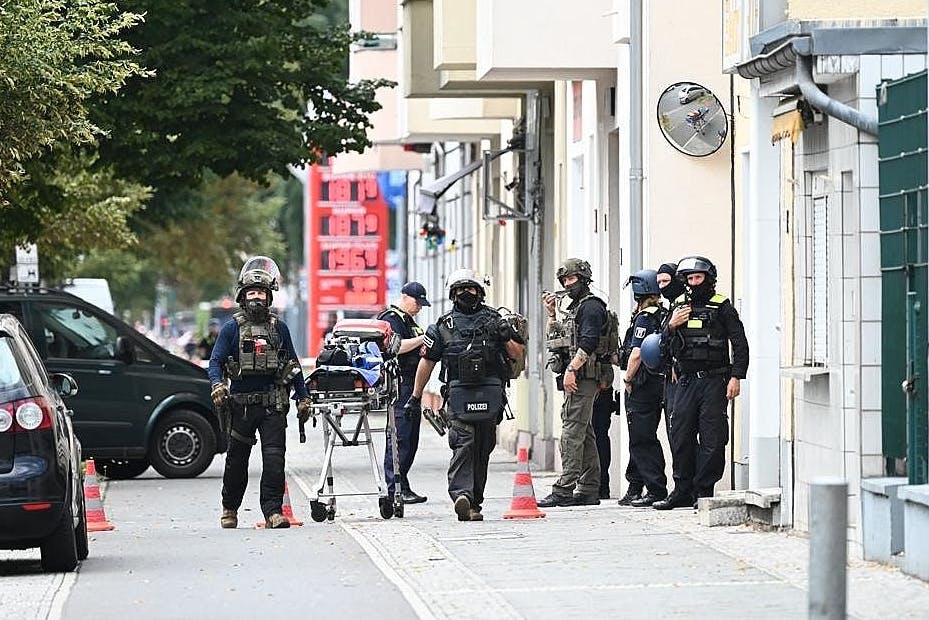 SEK-Beamte stehen vor einem Wohnhaus am Brunsbütteler Damm. 