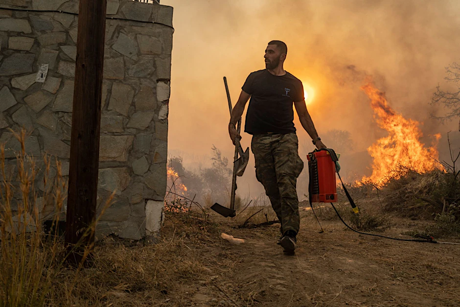 Ein Helfer kämpft gegen die Flammen im Dorf Gennadi auf der griechischen Insel Rhodos.