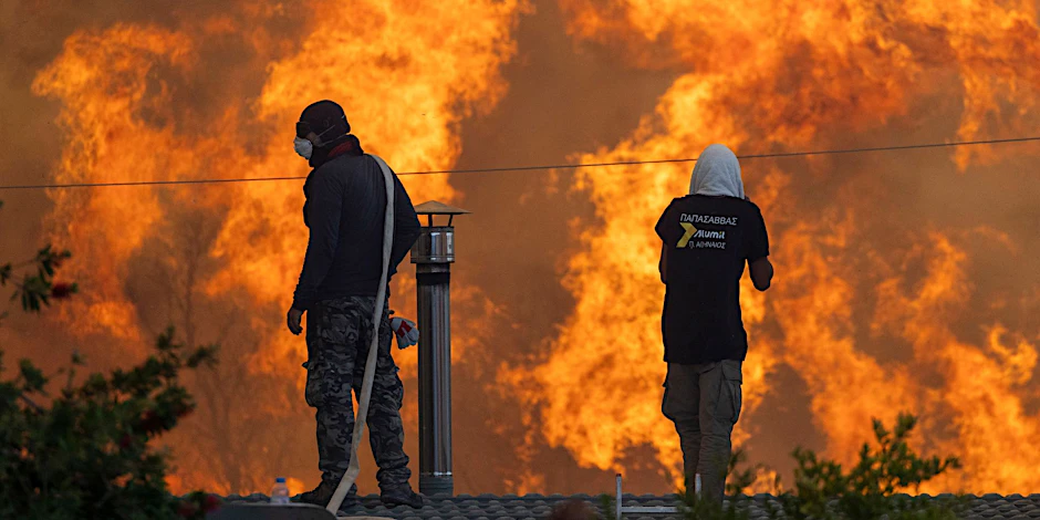 Anwohner der Ortschaft Gennadi auf der griechischen Insel Rhodos stehen auf ihren Dächern vor riesigen Flammen und versuchen mit Wasserschläuchen ihre Häuser zu retten.&nbsp;
